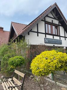 un banco frente a una casa con flores amarillas en Apartamenty Mitori, en Dywity