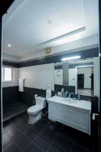 uma casa de banho com um WC, um lavatório e um espelho. em SK Residence em Islamabad