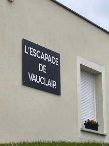 un panneau sur le côté d'un bâtiment avec une fenêtre dans l'établissement Escapade de Vauclair, à Bouconville-Vauclair