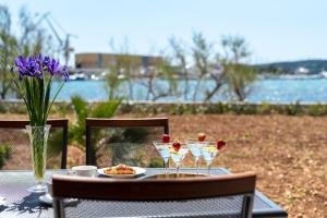 un tavolo con un piatto di bicchieri da cibo e vino di Infinity Residence a Trogir