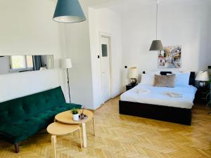 Un dormitorio con una cama y un sofá verde. en Cismigiu Park View, en Bucarest