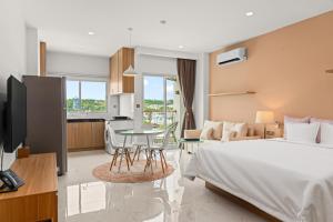 MLZ Apartments Sihanoukville في سيهانوكفيل: غرفة نوم بسرير وطاولة ومطبخ