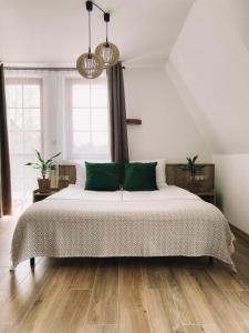 a bedroom with a large bed with green pillows at Końska Dolina in Tylicz