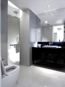 a white bathroom with a sink and a toilet at Rongratana Executive Residence in Bangkok