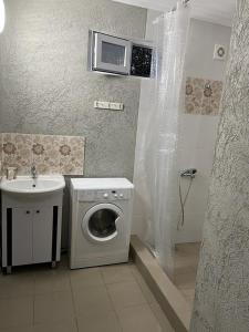 a bathroom with a washing machine and a sink at Guest House San Tina in Gagra