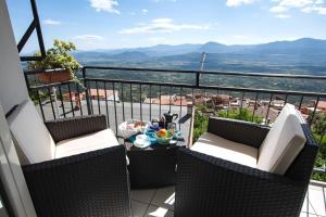 balcone con 2 sedie e tavolo con vista di Window on the Ogliastra apartment in Baunei a Baunei