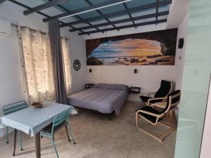sypialnia z łóżkiem, stołem i krzesłami w obiekcie BELLAMAR w mieście Barbate