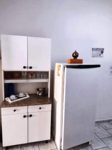 a kitchen with a white refrigerator in a room at Hospedagem Progresso in Juiz de Fora
