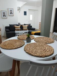 a white dining room table with four large wooden plates on it at La bella casa thassos in Limenas