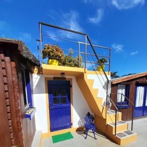 a house with a blue door and a balcony at Casa Lantana in Figueira da Foz