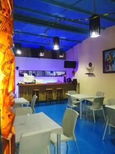 un restaurante con mesas y sillas blancas y techos púrpuras en Hotel Gavas Amazonas, en Leticia