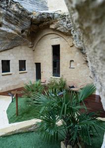 ein Steingebäude mit Pflanzen davor in der Unterkunft Le temps suspendu, Suite troglodyte & SPA privé in Doué-la-Fontaine