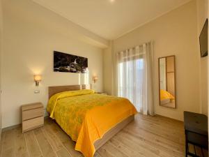 a bedroom with a bed with a yellow bedspread at CASANTO' in San Demetrio neʼ Vestini