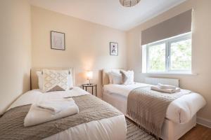 1 Schlafzimmer mit 2 Betten und einem Fenster in der Unterkunft Axinite - 3 Bedroom Flat With Parking in Southampton