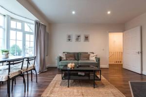 ein Wohnzimmer mit einem grünen Sofa und einem Tisch in der Unterkunft Axinite - 3 Bedroom Flat With Parking in Southampton