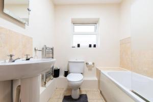 a bathroom with a sink and a toilet and a bath tub at Axinite - 3 Bedroom Flat With Parking in Southampton