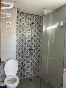 a bathroom with a toilet and a glass shower at HOTEL DEL MAR MAZAGAN in El Jadida