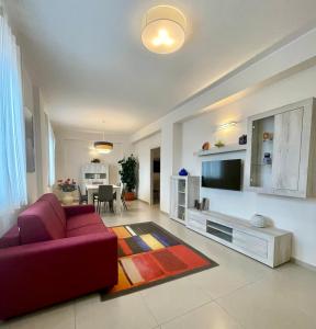 sala de estar con sofá rojo y TV en CASANTO', en San Demetrio neʼ Vestini
