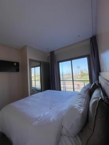 傑迪代的住宿－HOTEL DEL MAR MAZAGAN，一间卧室设有一张大床和大窗户
