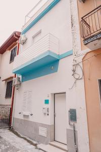 een wit gebouw met een deur en een balkon bij VACANZE Il PROFUMO DEL MARE in Pozzallo