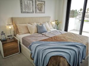 Un dormitorio con una cama grande con una manta azul. en Bahia Homes Torrevieja, en Torrevieja