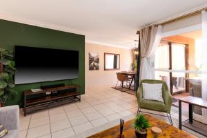 un salon avec une télévision à écran plat sur un mur vert dans l'établissement San Lameer Villa 3502 by Top Destinations Rentals, à Southbroom