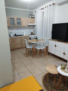 a kitchen with a table and chairs and a tv at La bella casa thassos in Limenas