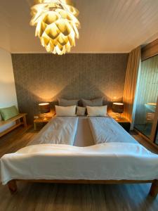 un grande letto in una camera da letto con lampadario a braccio di Doppelzimmer mit Bad & Balkon a Simmersfeld