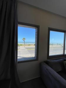 a room with two windows with a view of the beach at HOTEL DEL MAR MAZAGAN in El Jadida