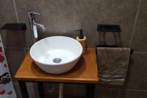um lavatório branco numa mesa de madeira na casa de banho em Hermoso alojamiento temporario LA SOÑADA em Pigüé