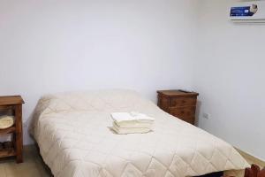 uma cama branca com duas toalhas em cima em Hermoso alojamiento temporario LA SOÑADA em Pigüé