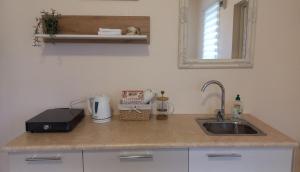 a kitchen counter with a sink and a mirror at SweetHome in Limbaži