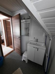 een badkamer met een wastafel, een spiegel en een douche bij Kenese Gyöngye Apartmanház in Balatonkenese