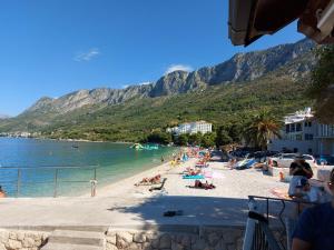 a group of people on a beach with mountains in the background at Apartman Matilda 2 in Gradac