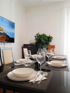 a dining room table with plates and wine glasses at Chalas place in Nazaré