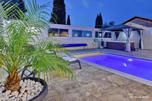 a swimming pool in the backyard of a house at שרדונה - סוויטה מהממת עם ג'קוזי ובריכה פרטית מחוממת ומקורה in ‘Ein Ya‘aqov