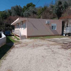 a house with a large roof on a gravel driveway at Apartment Tanja in Mrčevac