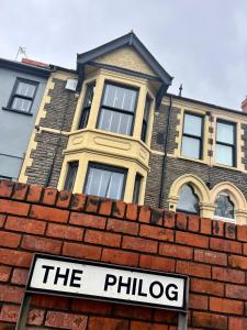 ein Backsteinhaus mit einem Schild über einer Ziegelmauer in der Unterkunft The Philog by Switchback Stays in Cardiff