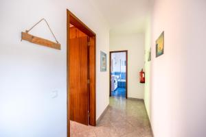 korytarz z drzwiami i znakiem na ścianie w obiekcie Local Guesthouse w mieście Sagres
