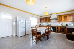 uma cozinha com uma mesa e um frigorífico branco em Local Guesthouse em Sagres