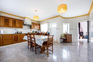 een keuken met een tafel en stoelen in een kamer bij Local Guesthouse in Sagres