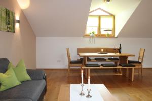 ein Wohnzimmer mit einem Tisch und einem Sofa in der Unterkunft Ferienwohnung am Dreiseithof in Hauzenberg