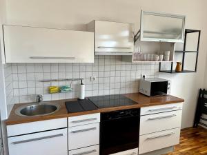 a kitchen with white cabinets and a sink at Condo Casa Di Olivia in Maribor