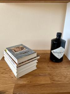 a stack of books on a table next to a bottle of alcohol at Condo Casa Di Olivia in Maribor