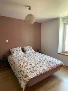 a bedroom with a bed with a comforter on it at Belle maison de ville rénovée in Lavardac