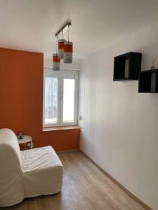 a living room with a white couch and a window at Belle maison de ville rénovée in Lavardac +1 photo