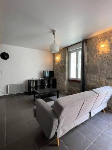 a living room with a couch and a table at Belle maison de ville rénovée in Lavardac