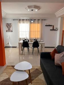 sala de estar con sofá, sillas y mesa en Appartement proche du Monument. Ouakam, en Dakar