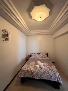 1 dormitorio con 1 cama con luz en el techo en Appartement proche du Monument. Ouakam, en Dakar