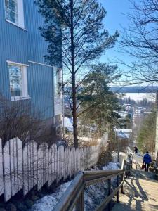 Cozy studio in Tampere for 2 with own Sauna,balcony and a free parking في تامبير: سور أمام منزل مع ثلج على الأرض